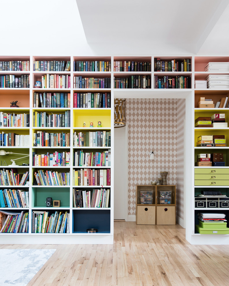 Idéer för funkis hemmabibliotek, med ljust trägolv och vita väggar