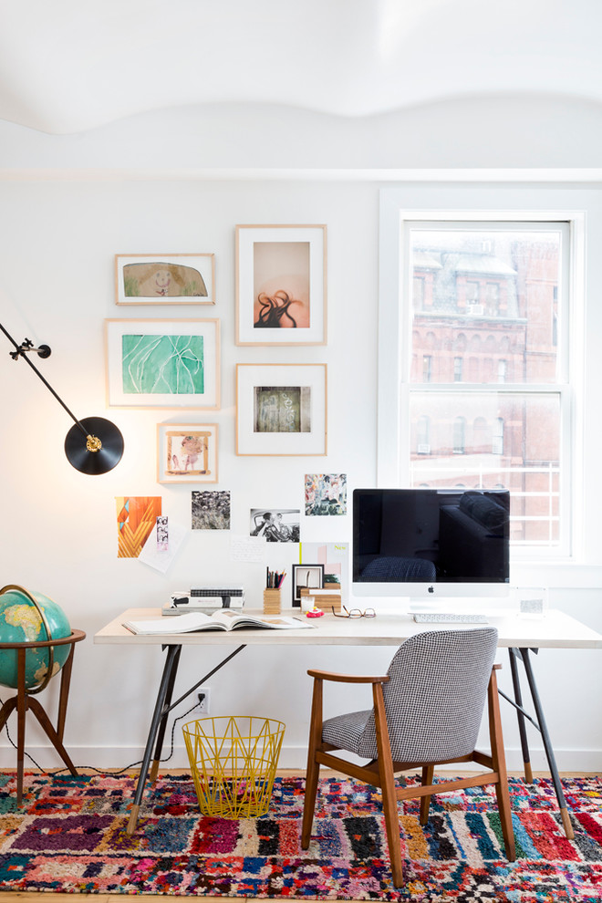На фото: рабочее место в современном стиле с белыми стенами и отдельно стоящим рабочим столом с