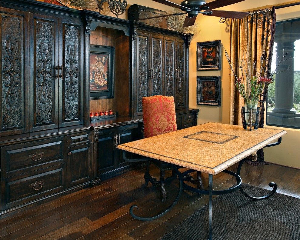 Ejemplo de despacho mediterráneo grande sin chimenea con paredes amarillas, suelo de madera oscura, escritorio independiente y suelo marrón