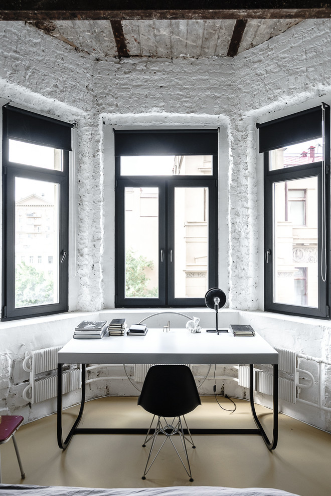 Cette image montre un bureau minimaliste avec un mur noir, sol en béton ciré et un sol beige.