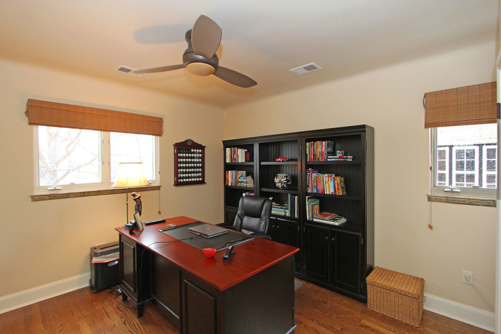 Kleines Klassisches Arbeitszimmer mit Arbeitsplatz, beiger Wandfarbe, braunem Holzboden und freistehendem Schreibtisch in Denver