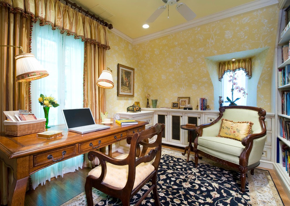 Foto di un piccolo ufficio tradizionale con pareti gialle, pavimento in legno massello medio e scrivania autoportante