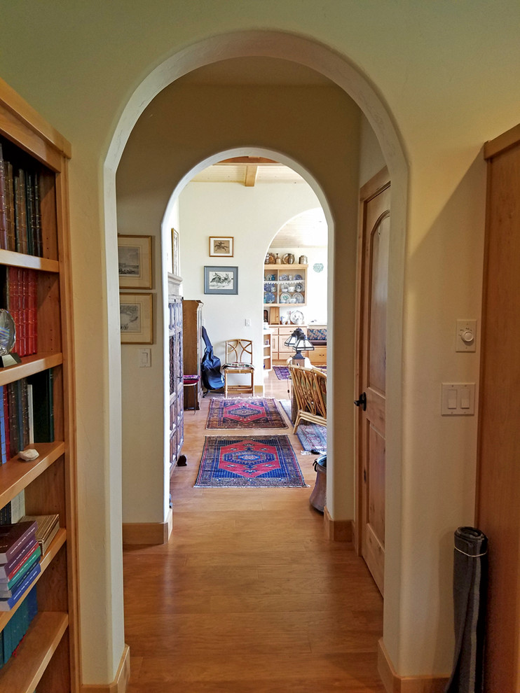 他の地域にある高級な中くらいなサンタフェスタイルのおしゃれな書斎 (緑の壁、ラミネートの床、自立型机) の写真