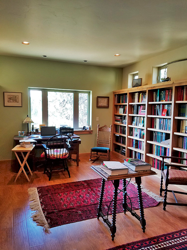 Inspiration för ett mellanstort amerikanskt hemmabibliotek, med gröna väggar, laminatgolv och ett fristående skrivbord