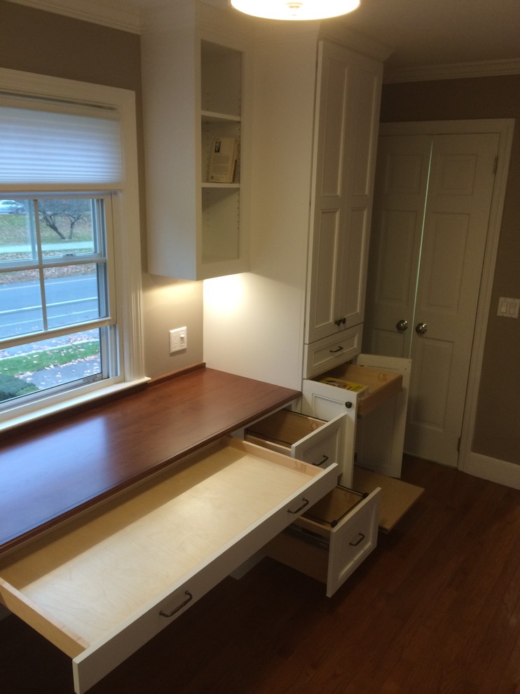 Cette photo montre un bureau chic avec un mur beige, un sol en bois brun et un bureau intégré.