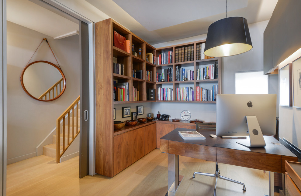Imagen de despacho actual pequeño con paredes grises, suelo de madera clara, escritorio independiente y suelo marrón