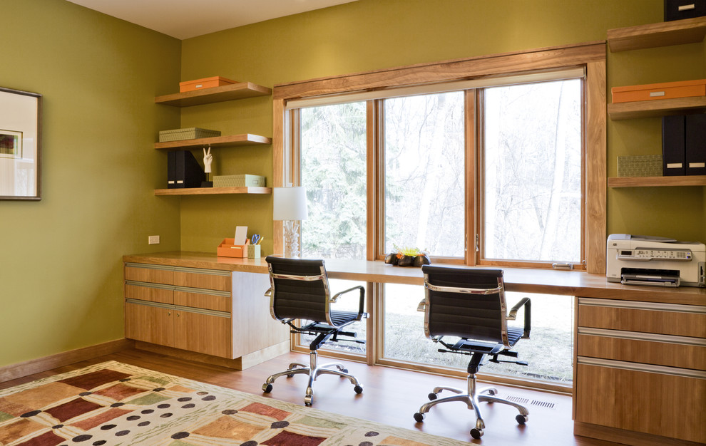 Idee per uno studio design con pareti verdi, pavimento in legno massello medio e scrivania incassata