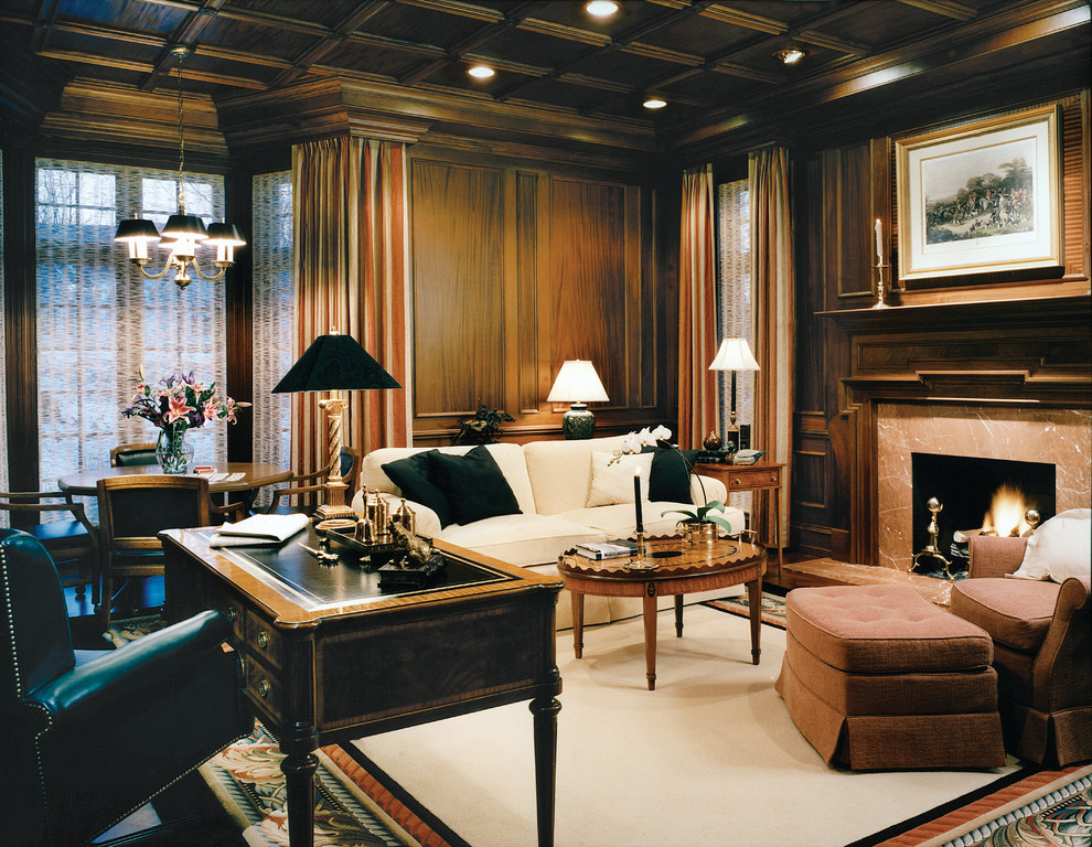Großes Klassisches Arbeitszimmer mit brauner Wandfarbe, dunklem Holzboden, Kamin, Kaminumrandung aus Stein, freistehendem Schreibtisch und weißem Boden in Detroit