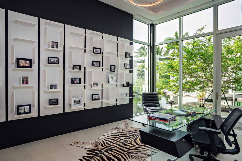 This is an example of a contemporary study in Miami with black walls and a freestanding desk.