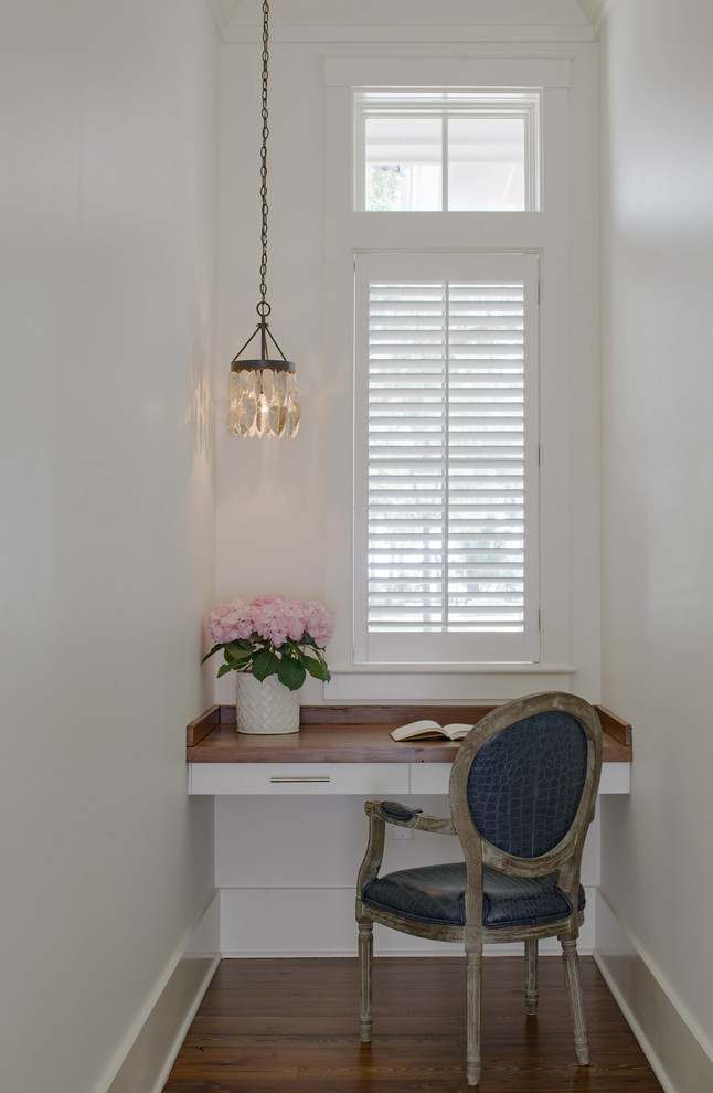 Foto di uno studio stile marinaro con pareti bianche, parquet scuro, scrivania incassata e pavimento marrone