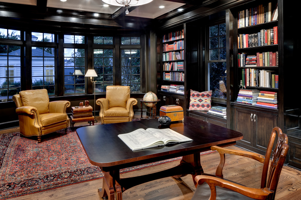 Imagen de despacho tradicional con paredes negras, suelo de madera en tonos medios y escritorio independiente