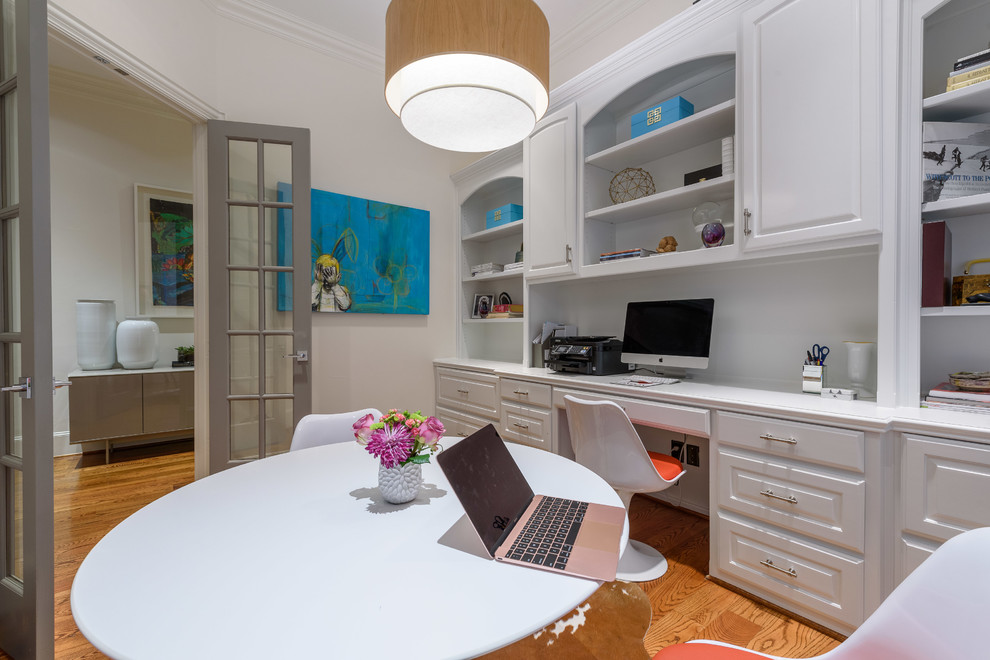 ダラスにある低価格の広いトランジショナルスタイルのおしゃれなホームオフィス・書斎 (ベージュの壁、淡色無垢フローリング、暖炉なし、造り付け机、茶色い床) の写真