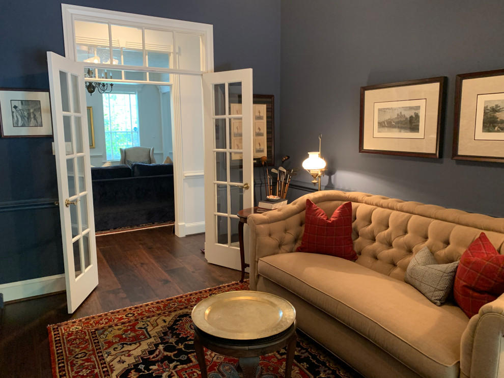 Exempel på ett litet klassiskt arbetsrum, med ett bibliotek, blå väggar, mellanmörkt trägolv och brunt golv