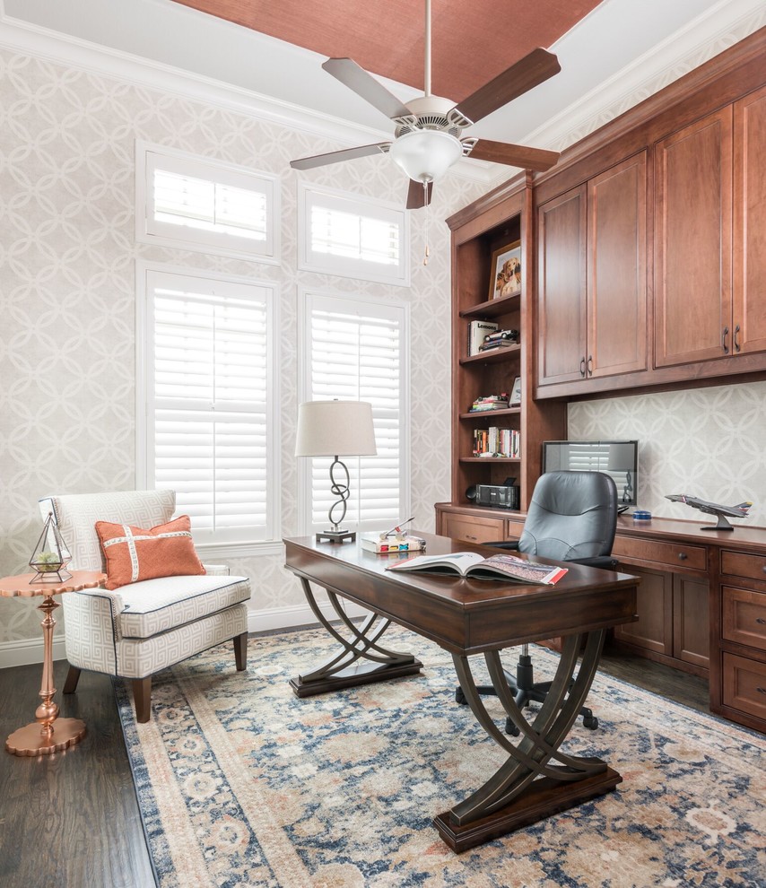 Modelo de despacho clásico renovado pequeño sin chimenea con paredes grises, suelo de madera oscura, escritorio independiente, suelo marrón y papel pintado