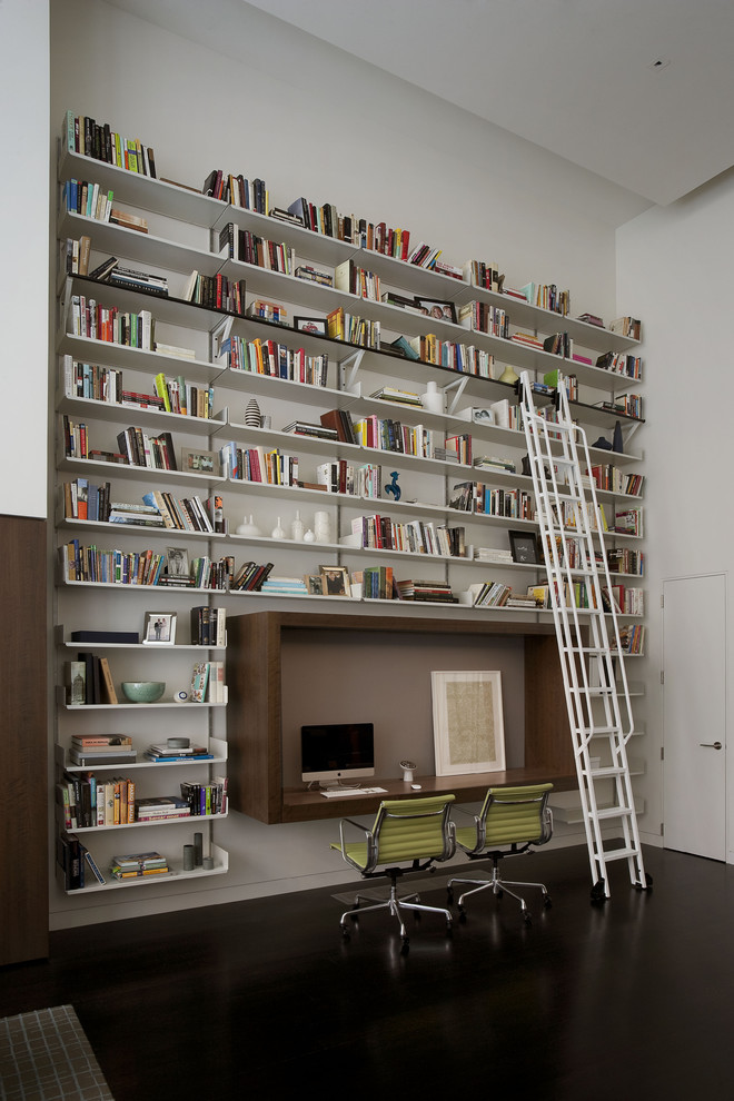 ニューヨークにあるコンテンポラリースタイルのおしゃれなホームオフィス・書斎 (白い壁、造り付け机、黒い床) の写真