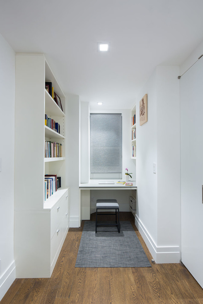 Idee per un piccolo ufficio contemporaneo con pareti bianche, pavimento in legno massello medio, nessun camino, scrivania incassata e pavimento marrone
