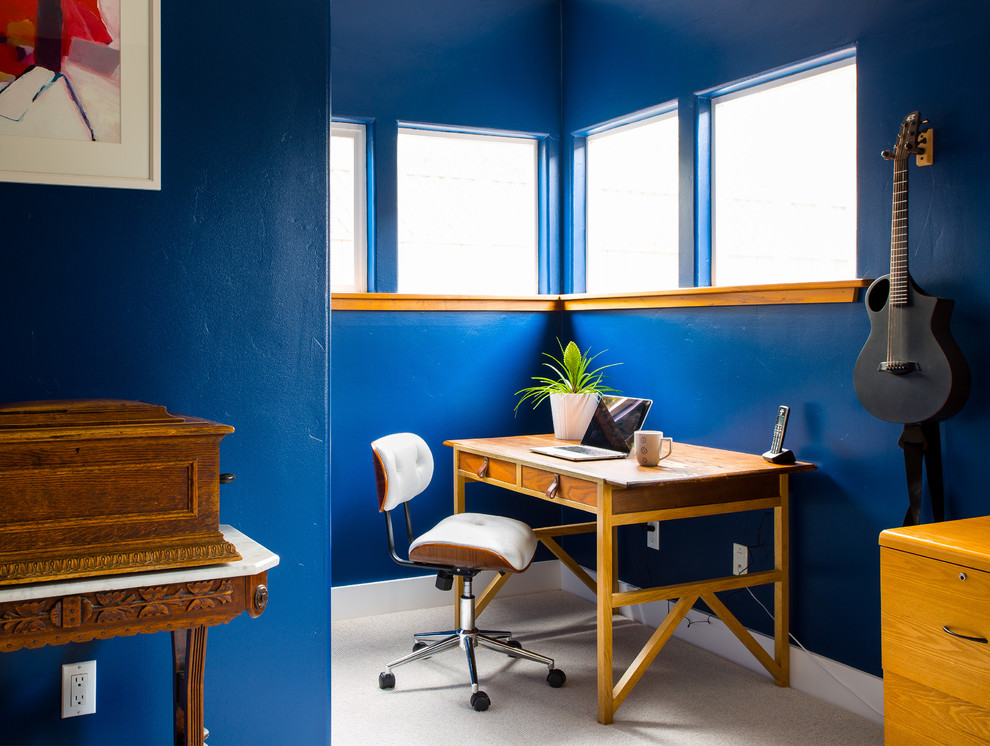 Idéer för att renovera ett eklektiskt hemmabibliotek, med blå väggar, heltäckningsmatta, ett fristående skrivbord och beiget golv