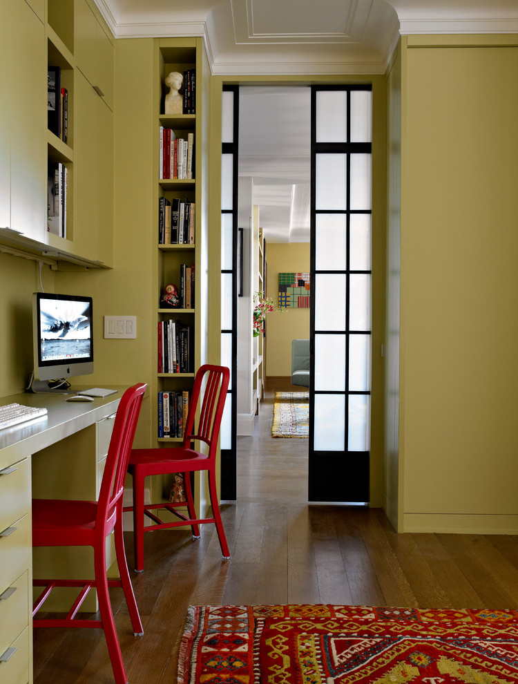 This is an example of a contemporary home office in New York with a built-in desk.