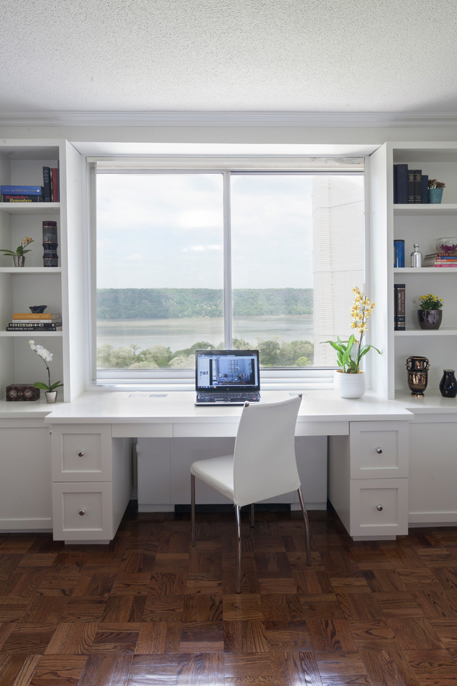 Пример оригинального дизайна: кабинет в стиле модернизм с белыми стенами, паркетным полом среднего тона и встроенным рабочим столом без камина