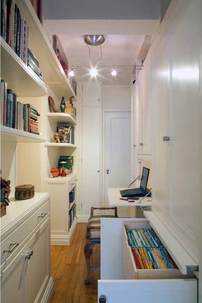 ニューヨークにある小さなトランジショナルスタイルのおしゃれなホームオフィス・書斎 (白い壁、淡色無垢フローリング、暖炉なし、造り付け机) の写真