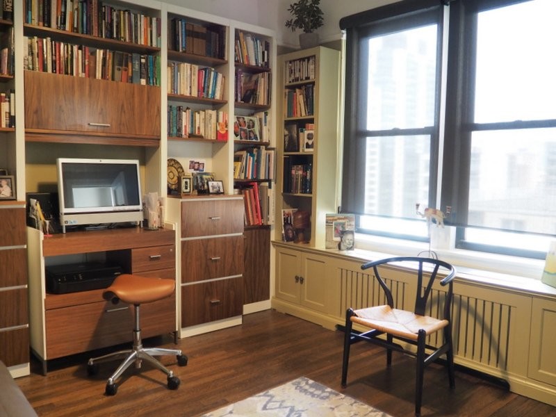 Foto di uno studio minimal di medie dimensioni con libreria, pavimento in legno massello medio, nessun camino e scrivania incassata