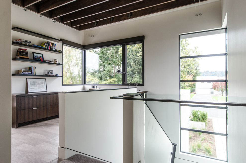 Diseño de despacho contemporáneo de tamaño medio sin chimenea con paredes blancas, suelo de madera clara, escritorio empotrado y suelo beige