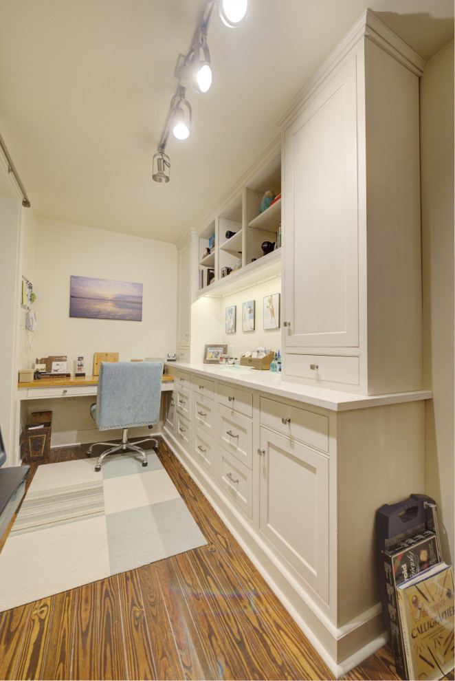 Immagine di un piccolo atelier classico con pareti bianche, pavimento in legno massello medio e scrivania incassata
