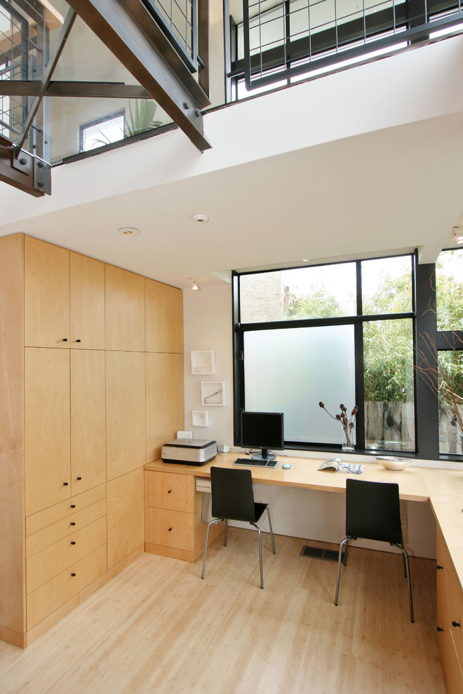 Источник вдохновения для домашнего уюта: маленький кабинет в современном стиле с белыми стенами, полом из бамбука и встроенным рабочим столом для на участке и в саду