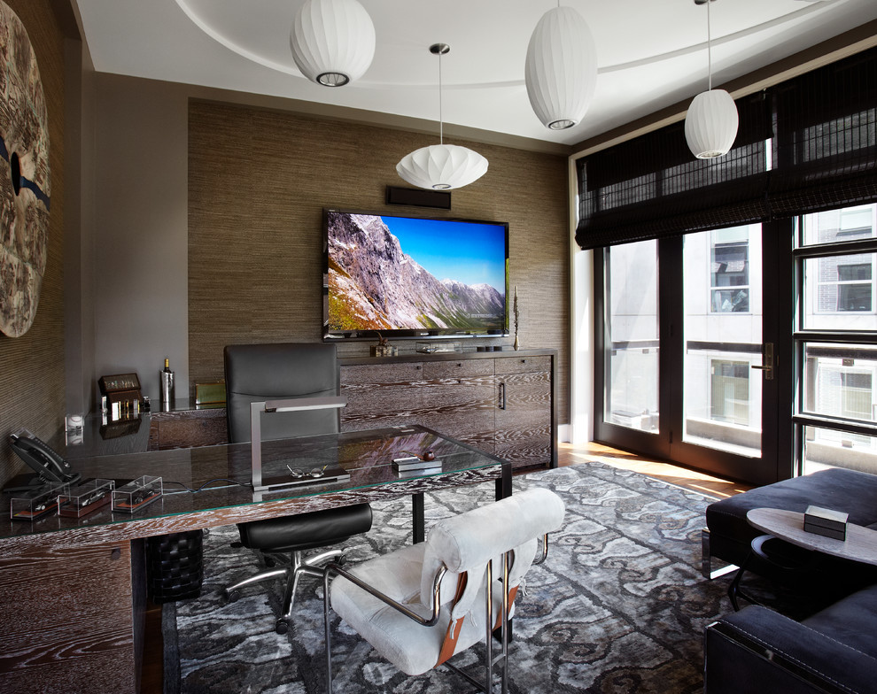 Ejemplo de despacho actual con paredes grises, suelo de madera en tonos medios y escritorio empotrado
