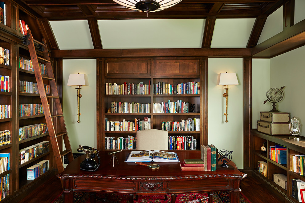 Inredning av ett klassiskt mellanstort hemmabibliotek, med gröna väggar, mörkt trägolv och ett fristående skrivbord