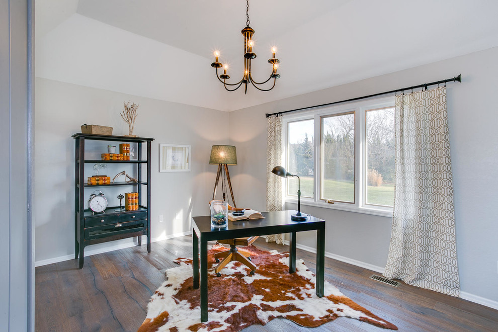 Farmhouse study in Wichita with grey walls, medium hardwood flooring and a freestanding desk.