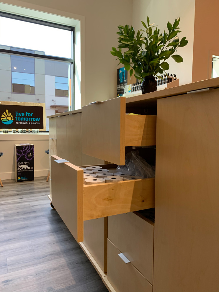 Mittelgroßes Uriges Arbeitszimmer mit Studio, brauner Wandfarbe, Sperrholzboden, Kaminofen, Kaminumrandung aus Holz, Einbau-Schreibtisch und weißem Boden in Vancouver