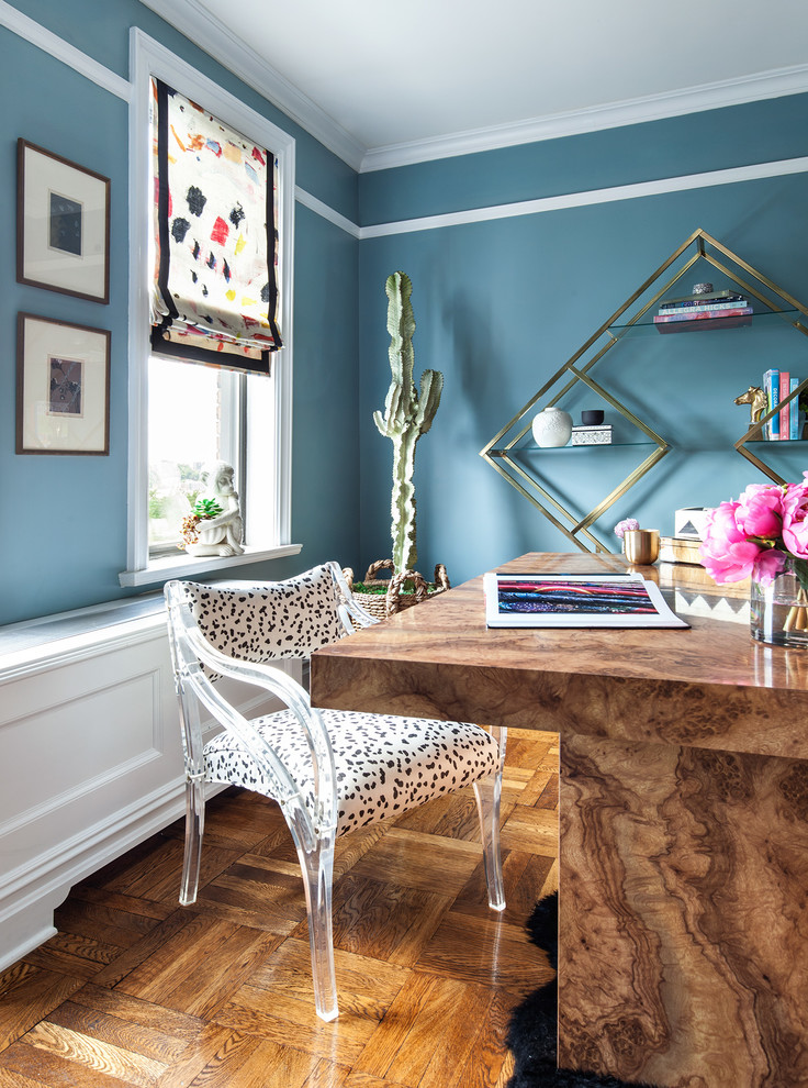 Photo of a medium sized eclectic study in New York with blue walls, medium hardwood flooring, no fireplace, a freestanding desk and brown floors.