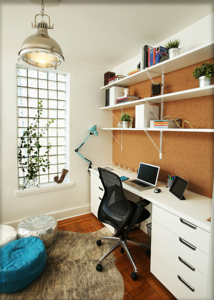 Small contemporary home office in New York with white walls, dark hardwood flooring and a built-in desk.