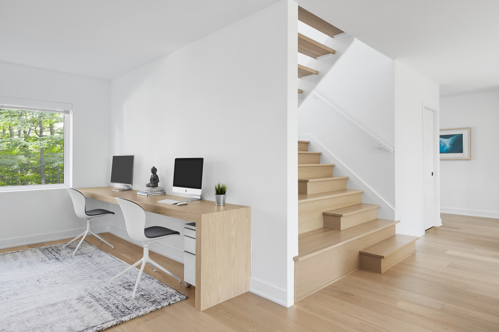 Idées déco pour un petit bureau moderne avec un mur blanc, parquet clair et un bureau intégré.