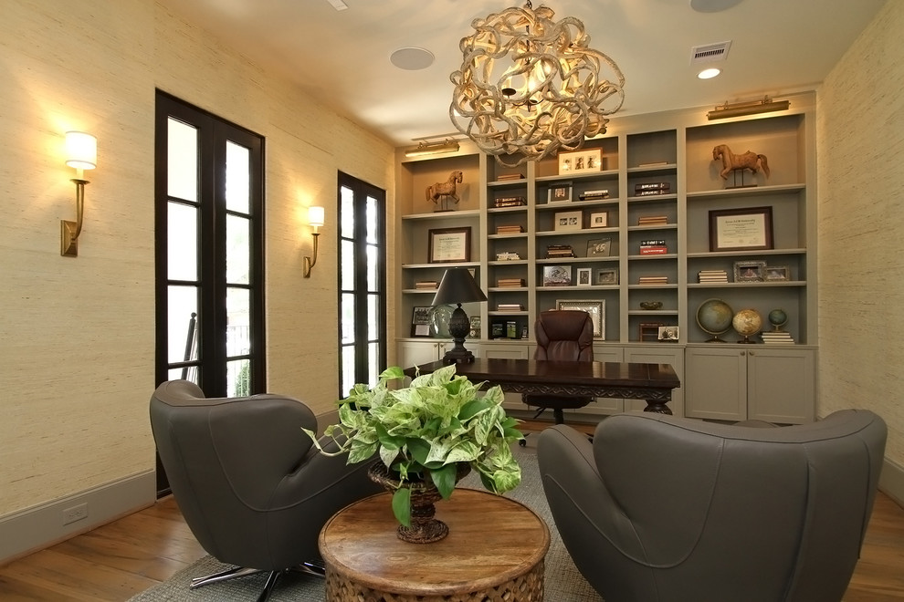 Modernes Arbeitszimmer mit beiger Wandfarbe, braunem Holzboden und freistehendem Schreibtisch in Houston