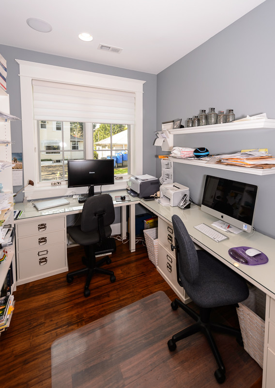 Diseño de despacho de estilo americano pequeño con paredes azules, escritorio empotrado y suelo de madera oscura