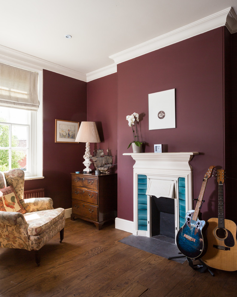 Mittelgroßes Klassisches Arbeitszimmer mit Studio, braunem Holzboden, Kamin und lila Wandfarbe in Sonstige