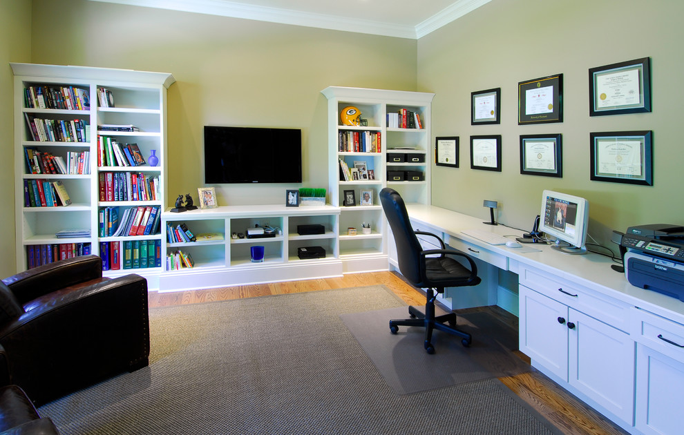 Cette image montre un bureau craftsman de taille moyenne et de type studio avec un mur vert, parquet clair et un bureau intégré.