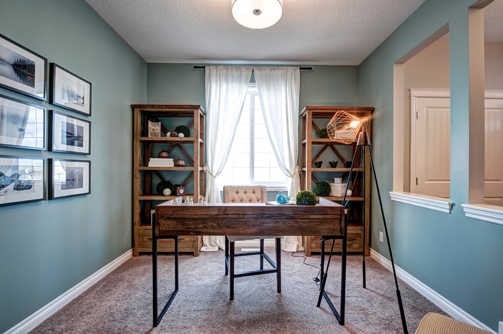 Großes Landhausstil Arbeitszimmer ohne Kamin mit blauer Wandfarbe, Teppichboden und freistehendem Schreibtisch in Calgary