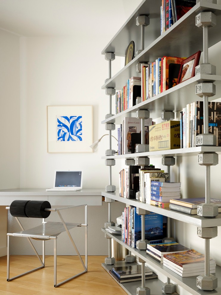 Modernes Arbeitszimmer mit weißer Wandfarbe, braunem Holzboden und Einbau-Schreibtisch in Los Angeles
