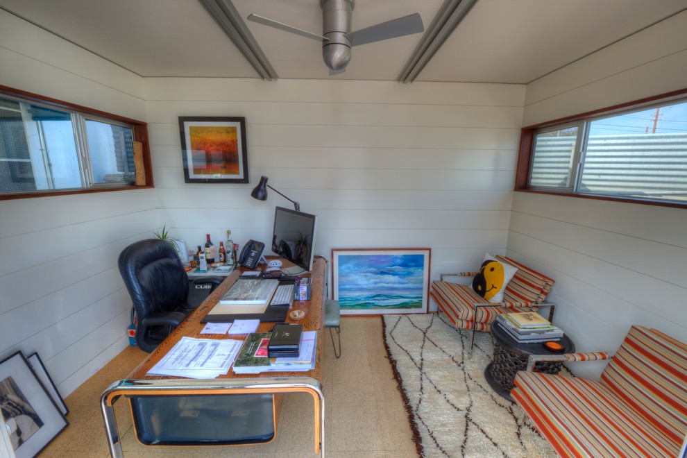 Ejemplo de despacho minimalista pequeño con paredes blancas, suelo de corcho y escritorio independiente