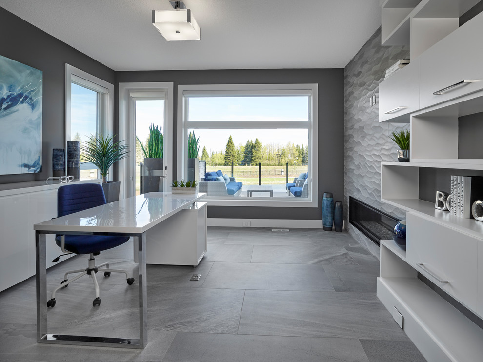 Study room - large contemporary freestanding desk ceramic tile and gray floor study room idea in Edmonton with gray walls, a two-sided fireplace and a tile fireplace