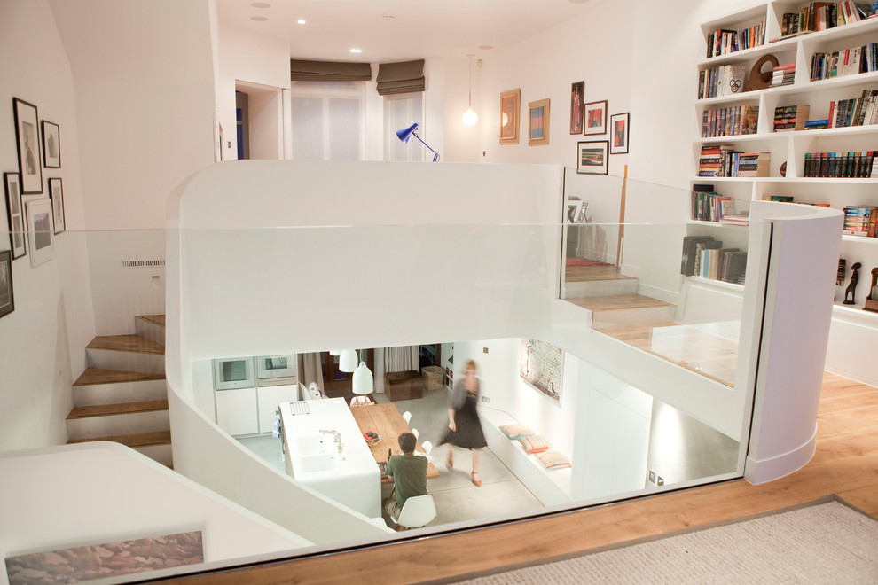 Mittelgroßes Modernes Arbeitszimmer mit weißer Wandfarbe und braunem Holzboden
