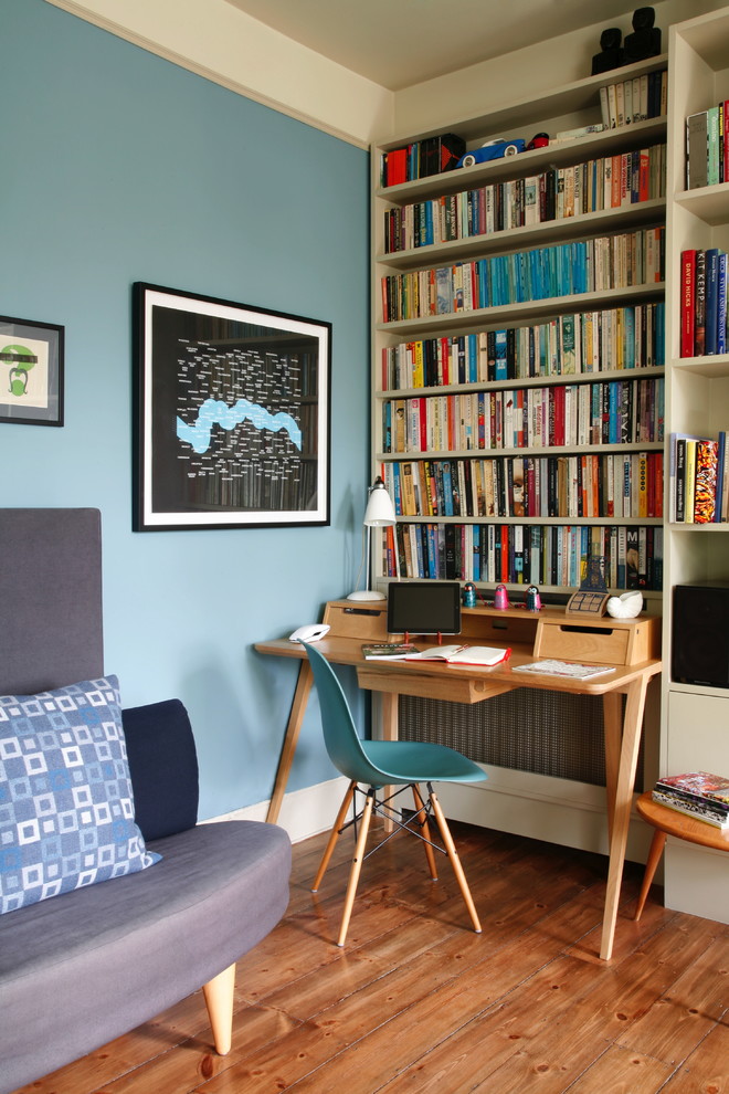 Study room - eclectic freestanding desk medium tone wood floor study room idea in London with blue walls