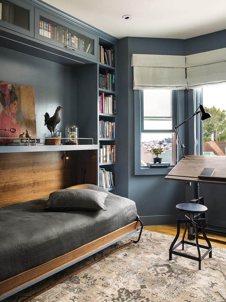 На фото: домашняя библиотека в стиле неоклассика (современная классика) с синими стенами, паркетным полом среднего тона и отдельно стоящим рабочим столом