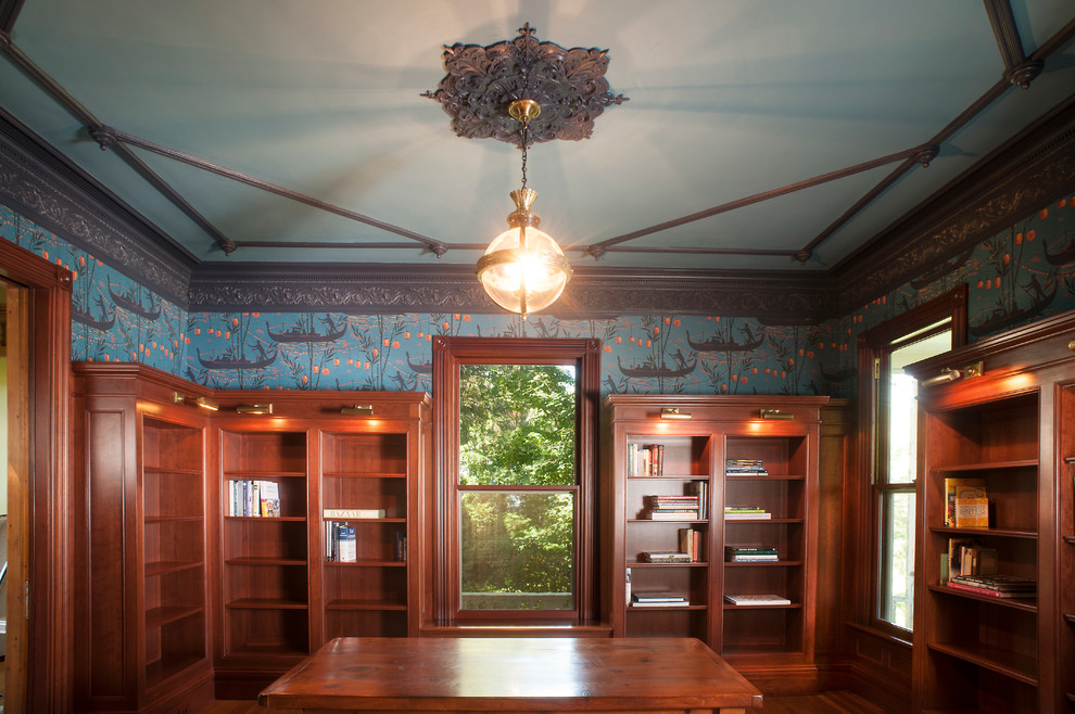Mittelgroßes Klassisches Lesezimmer ohne Kamin mit blauer Wandfarbe, braunem Holzboden, freistehendem Schreibtisch und braunem Boden in Portland Maine