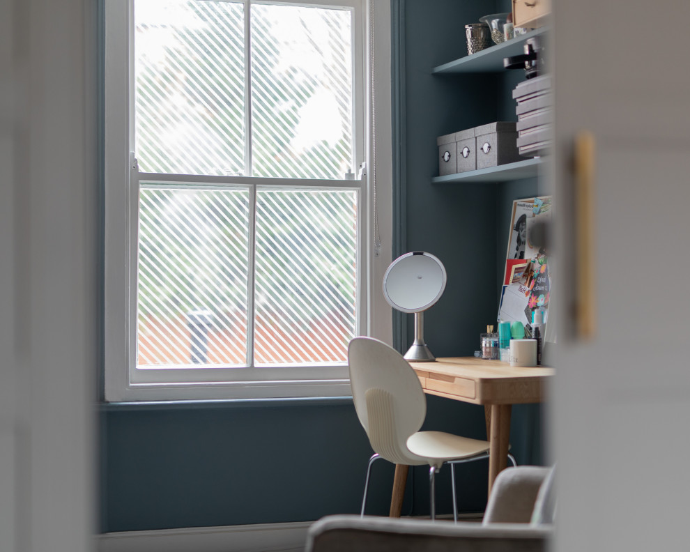 Cette photo montre un bureau atelier tendance de taille moyenne avec un mur bleu, moquette, une cheminée standard, un manteau de cheminée en carrelage, un bureau indépendant et un sol gris.