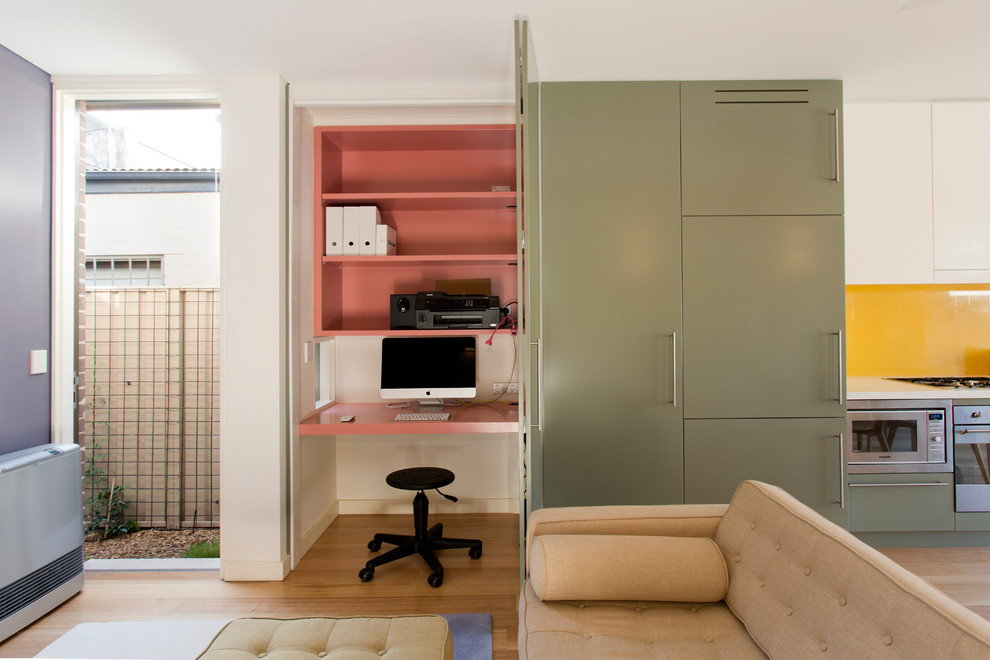 Imagen de despacho contemporáneo pequeño sin chimenea con suelo de madera clara y escritorio empotrado