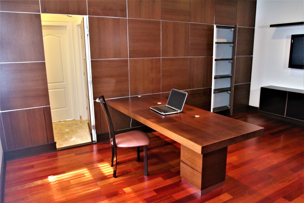 Foto de despacho contemporáneo de tamaño medio con biblioteca, suelo de madera oscura y escritorio empotrado